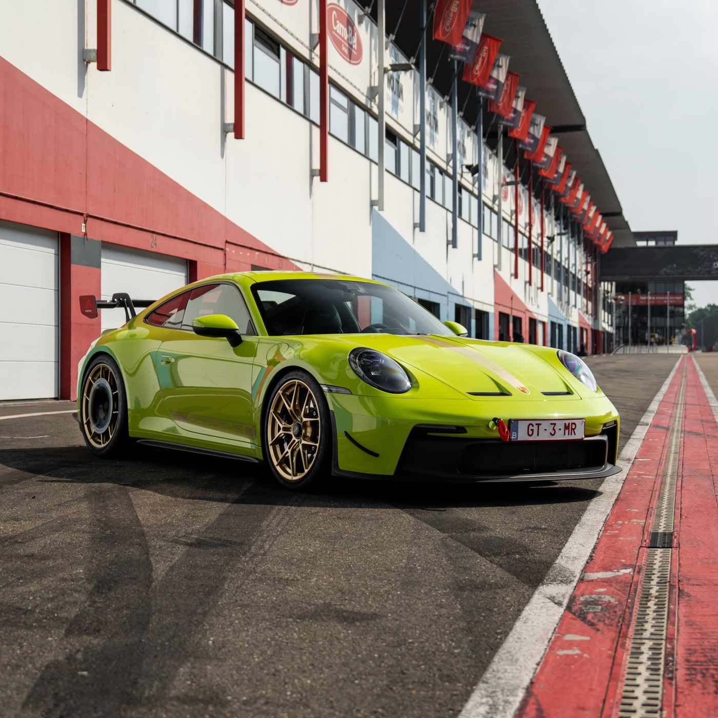 Lime green track car in a daylight pit lane